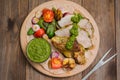 Meat with vegetables, grilled and served Italian Salsa Verde sauce. Wooden rustic table. Close-up