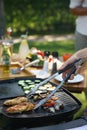 Meat and vegetables grilling on outdoor grill. Outdoor grill or BBQ party in the garden. Royalty Free Stock Photo