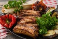 The meat and vegetables roasted on a grill with fresh greens black plate in style rustic Royalty Free Stock Photo