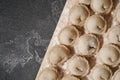 Meat or vegeterian dumplings, pelmeni on a wooden board on a dark grey table. Russian national food. Close up top view. Royalty Free Stock Photo