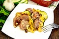 Meatballs with cheese and squash in plate on dark board