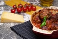 Meatballs with tomato sauce and decorated with basil leaf, served in white and red pan on grey background. next to the pan near Royalty Free Stock Photo