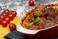 Meatballs with tomato sauce and decorated with basil leaf, served in white and red pan on grey background. next to the pan near Royalty Free Stock Photo