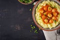 Meatballs in tomato sauce with mashed potatoes in bowl.