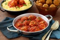 Meatballs in tomato sauce in metal pan on table with italian pasta Royalty Free Stock Photo