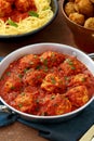 Meatballs in tomato sauce in metal pan on table with italian pasta Royalty Free Stock Photo