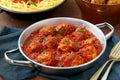 Meatballs in tomato sauce in metal pan on table with italian pasta Royalty Free Stock Photo