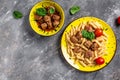 Meatballs in tomato sauce with penne pasta on a yellow plate and a gray background. banner, menu recipe place for text, top view Royalty Free Stock Photo
