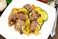 Meatballs with zucchini and cheese in plate on dark board