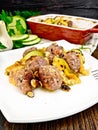 Meatballs with zucchini and nuts in plate on darkt board