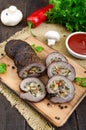 Meatloaf roll stuffed with mushrooms, sweet pepper and tomato sauce on a dark wooden background. Royalty Free Stock Photo