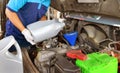 Mechanic adding Engine oil for quality into the engine motor car