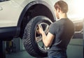 Mechanic adjusting tire wheel at repair garage Royalty Free Stock Photo