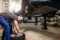 Mechanic adjusting tire wheel at repair garage Royalty Free Stock Photo