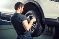 Mechanic adjusting tire wheel at repair garage Royalty Free Stock Photo