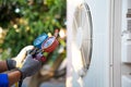 Mechanic air conditioner technician using manifold gauge checking refrigerant for filling home air conditioning Royalty Free Stock Photo