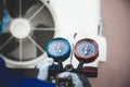 Mechanic air conditioner technician using manifold gauge checking refrigerant for filling home air conditioning and air duct Royalty Free Stock Photo