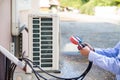 Mechanic air conditioner technician using manifold gauge checking refrigerant for filling home air conditioning and air duct Royalty Free Stock Photo