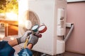 Mechanic air conditioner technician using manifold gauge checking refrigerant for filling home air conditioning and air duct Royalty Free Stock Photo