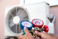 Mechanic air repair using manifold gauge for filling home air conditioner