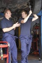 Mechanic and apprentice working on car Royalty Free Stock Photo