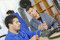 Mechanic and apprentice working on car with computer Royalty Free Stock Photo