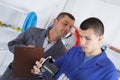 mechanic and apprentice working on car with computer Royalty Free Stock Photo