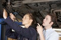 Mechanic And Apprentice Working On Car Together Royalty Free Stock Photo