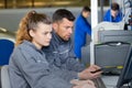 Mechanic and apprentice working on computer