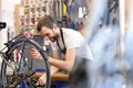 Mechanic in a bicycle repair shop oiling the chain of a bike