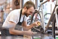 Mechanic in a bicycle repair shop oiling the chain of a bike