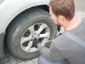 The mechanic brunette changes the wheel of the white car outside. Royalty Free Stock Photo
