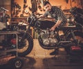 Mechanic building vintage style cafe-racer motorcycle