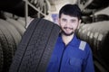 Mechanic carrying tire in the store Royalty Free Stock Photo