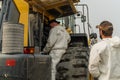 A mechanic changes the filter in a Komatsu loader during service.