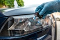 Mechanic changing car light bulb against headlight