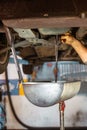 Mechanic changing car oil in car service workshop Royalty Free Stock Photo