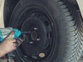 Mechanic changing a car tire in a workshop on a vehicle on a hoist using an electric drill to loosen the bolts in a concept of Royalty Free Stock Photo