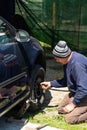 Mechanic changing wheel on car with manual wrench. Mechanic replacing tires in Bucharest, Romania, 2021