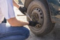 Mechanic changing wheel on car with a wrench. Royalty Free Stock Photo