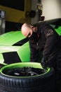 Mechanic changing the wheels of a high-end super sports car. Auto mechanic working in garage. Repair service. Royalty Free Stock Photo