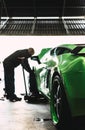 Mechanic changing the wheels of a high-end super sports car. Auto mechanic working in garage. Repair service. Royalty Free Stock Photo