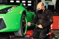 Mechanic changing the wheels of a high-end super sports car. Auto mechanic working in garage. Repair service. Royalty Free Stock Photo