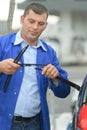 Mechanic changing windshield wiper blades on car