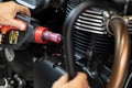 Mechanic Check and pouring engine oil to motorcycle at garage, Motorcycle maintenance and service and repair concept . selective Royalty Free Stock Photo