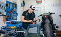 Mechanic checking custom motorcycle with tablet Royalty Free Stock Photo