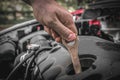 Mechanic checking the oil level in a car engine Royalty Free Stock Photo