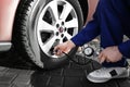 Mechanic checking tire air pressure at car service Royalty Free Stock Photo