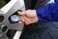 Mechanic checking tire air pressure at car service Royalty Free Stock Photo