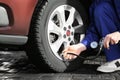 Mechanic checking tire air pressure at car service Royalty Free Stock Photo